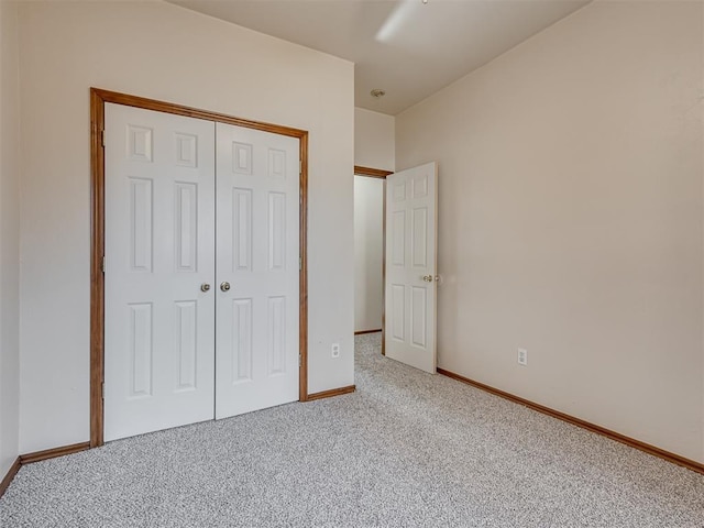 unfurnished bedroom with light colored carpet and a closet