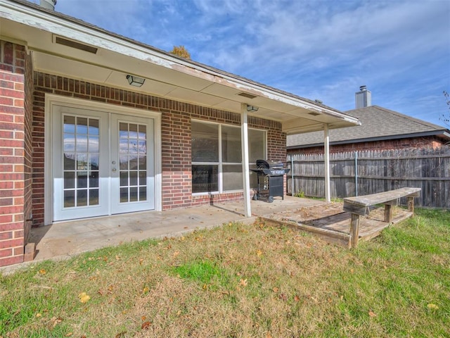 rear view of house featuring french doors, a patio, and a lawn