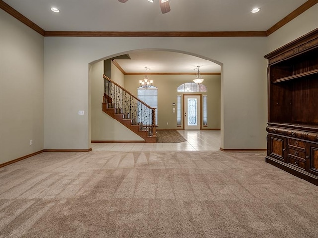 interior space with ceiling fan with notable chandelier, light colored carpet, and crown molding