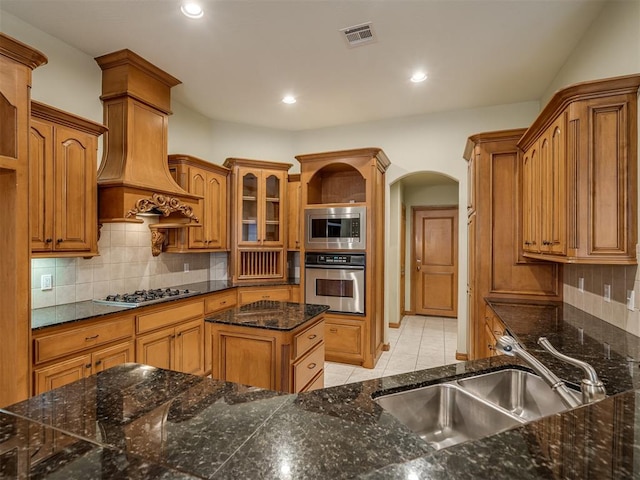 kitchen featuring decorative backsplash, sink, light tile patterned floors, and appliances with stainless steel finishes