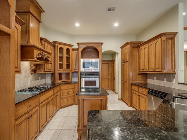 kitchen featuring decorative backsplash, appliances with stainless steel finishes, premium range hood, and light tile patterned floors