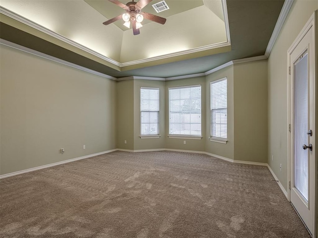 spare room with ceiling fan, ornamental molding, carpet floors, and a tray ceiling