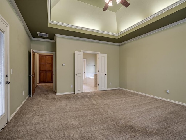 unfurnished bedroom featuring a raised ceiling, ceiling fan, crown molding, and light carpet