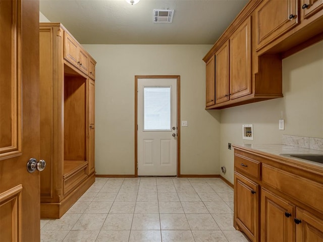 laundry room featuring cabinets, hookup for a washing machine, light tile patterned floors, and electric dryer hookup