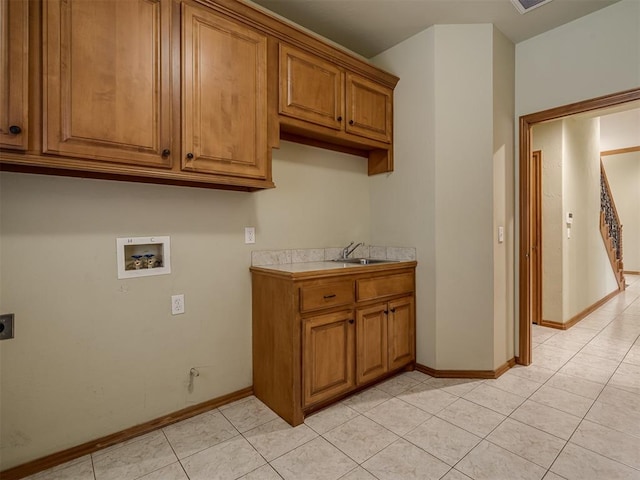 laundry room with electric dryer hookup, cabinets, sink, washer hookup, and light tile patterned flooring