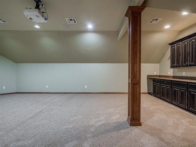 additional living space with light colored carpet, vaulted ceiling, and ornate columns