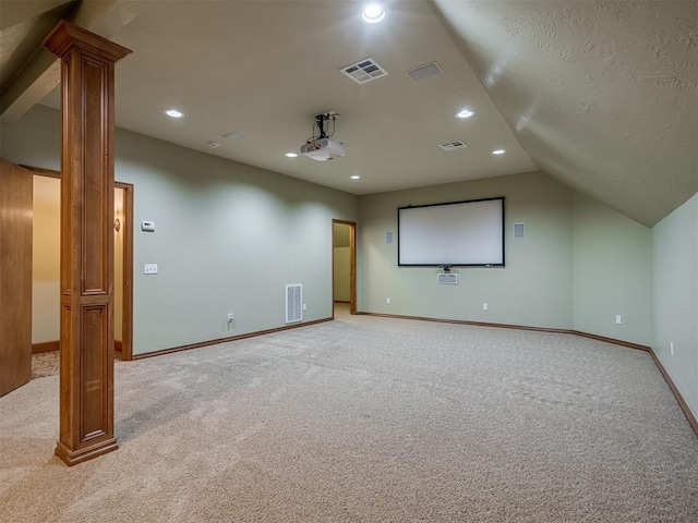 carpeted home theater featuring lofted ceiling