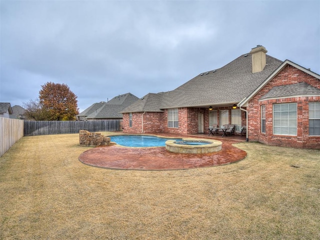 view of swimming pool with a yard and an in ground hot tub