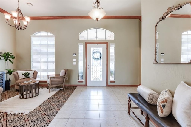 entrance foyer featuring light tile patterned floors, ornamental molding, baseboards, visible vents, and a notable chandelier