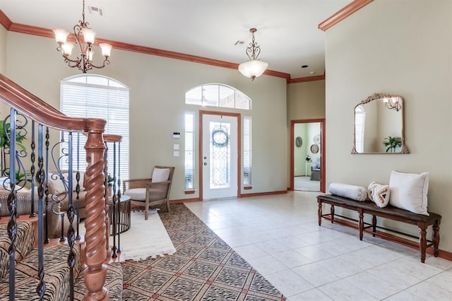 foyer with visible vents, baseboards, ornamental molding, a notable chandelier, and light tile patterned floors