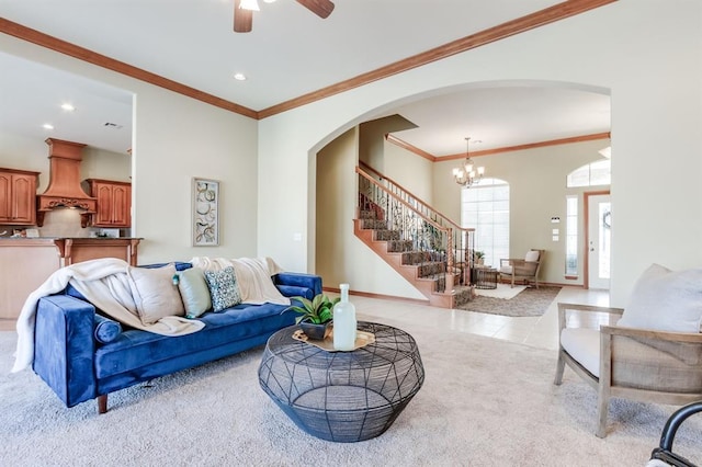 living room featuring arched walkways, stairs, baseboards, and light colored carpet