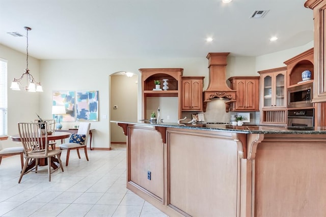 kitchen with visible vents, oven, stainless steel microwave, open shelves, and backsplash