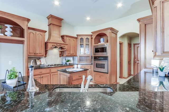 kitchen with a sink, open shelves, premium range hood, and appliances with stainless steel finishes