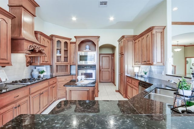 kitchen with visible vents, custom exhaust hood, stainless steel appliances, arched walkways, and a sink