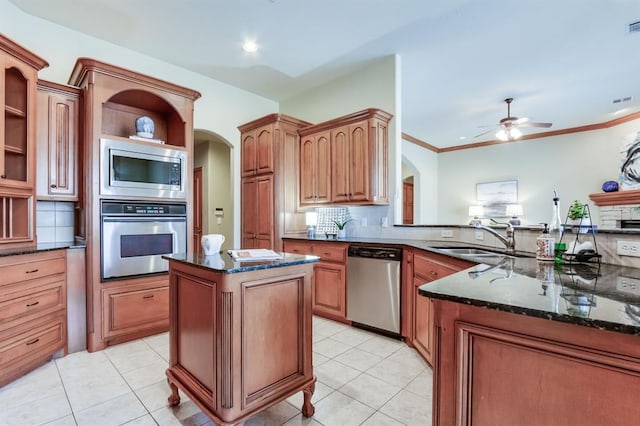kitchen featuring a sink, arched walkways, appliances with stainless steel finishes, and open shelves