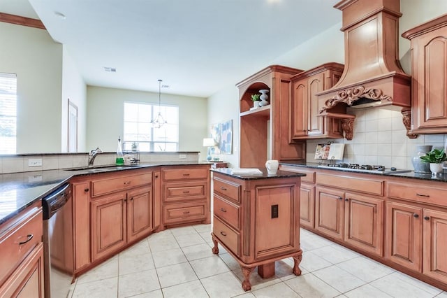 kitchen featuring dark stone counters, premium range hood, appliances with stainless steel finishes, a sink, and backsplash