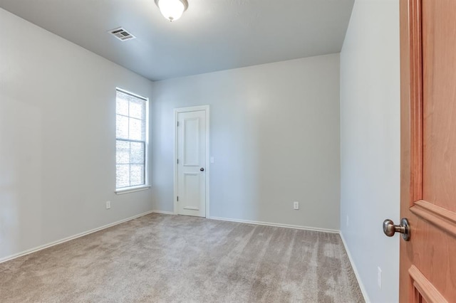 carpeted spare room featuring baseboards and visible vents