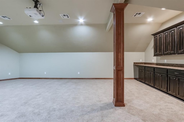 additional living space featuring visible vents, decorative columns, and light colored carpet