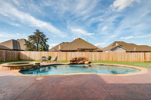 view of pool with a fenced backyard, a pool with connected hot tub, and a patio area