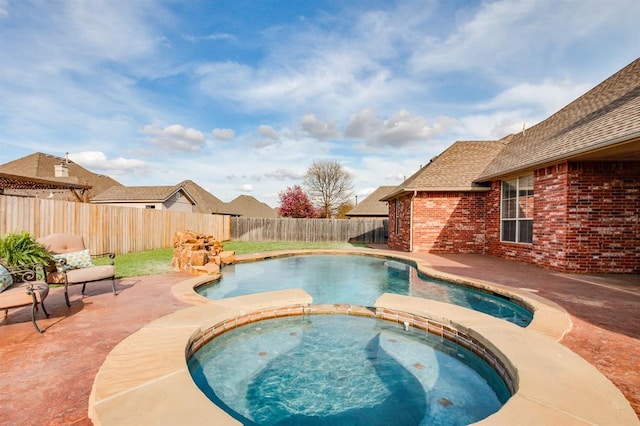 view of pool featuring a fenced backyard, a pool with connected hot tub, and a patio