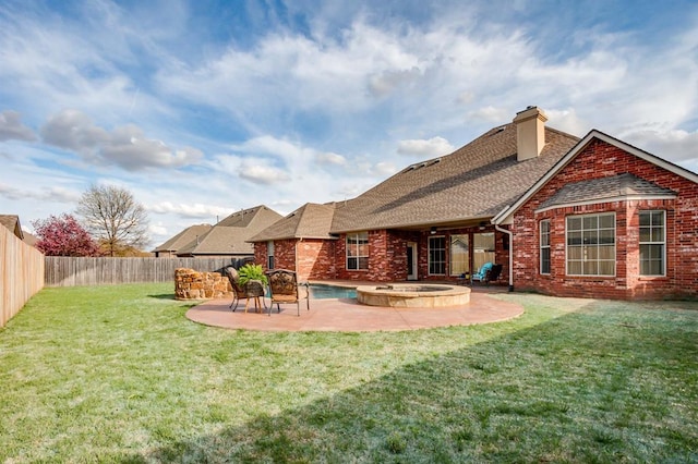 back of house featuring a fenced backyard, brick siding, and a patio