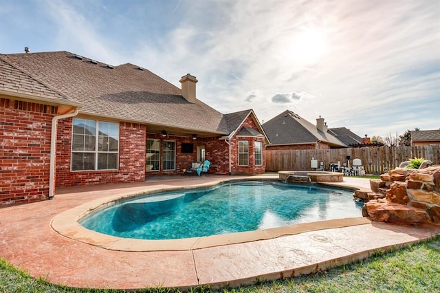 view of pool featuring a fenced backyard, a pool with connected hot tub, a patio area, and a ceiling fan