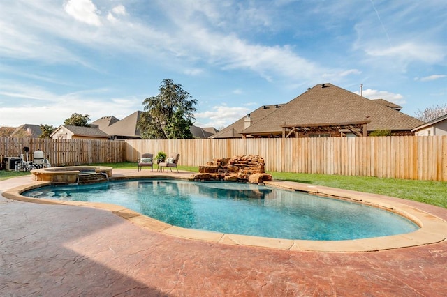 view of pool featuring a fenced backyard, a pool with connected hot tub, and a patio area