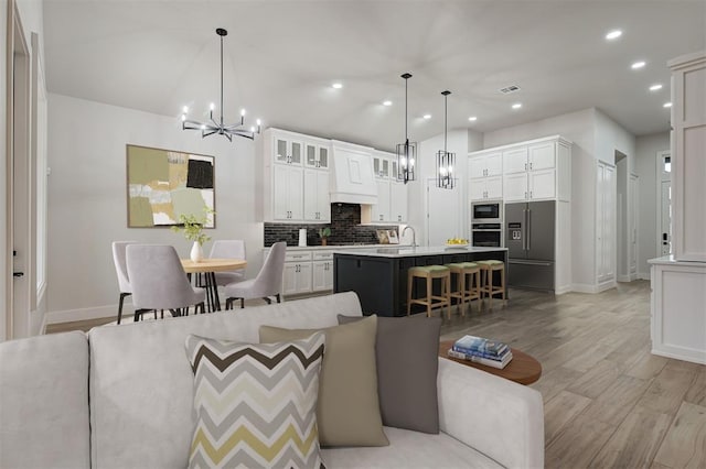 interior space featuring light hardwood / wood-style floors, sink, and a notable chandelier