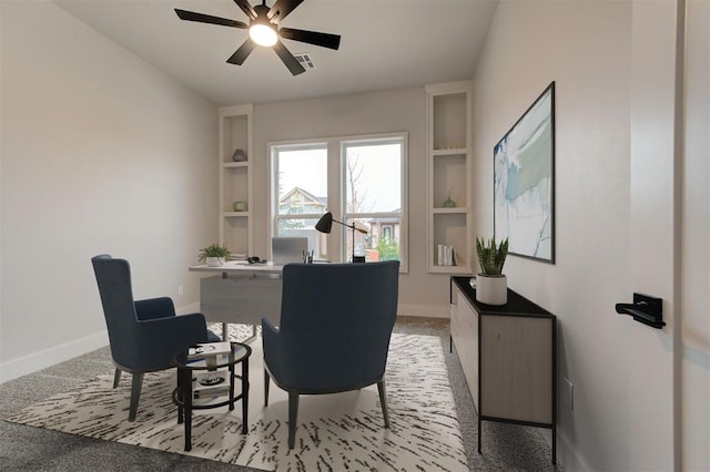 office area with ceiling fan, light colored carpet, and built in shelves