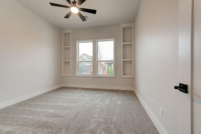 carpeted empty room featuring ceiling fan and built in features