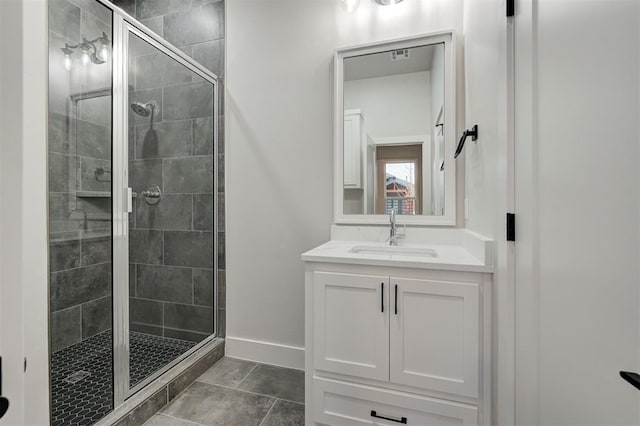 bathroom featuring tile patterned flooring, a shower with shower door, and vanity