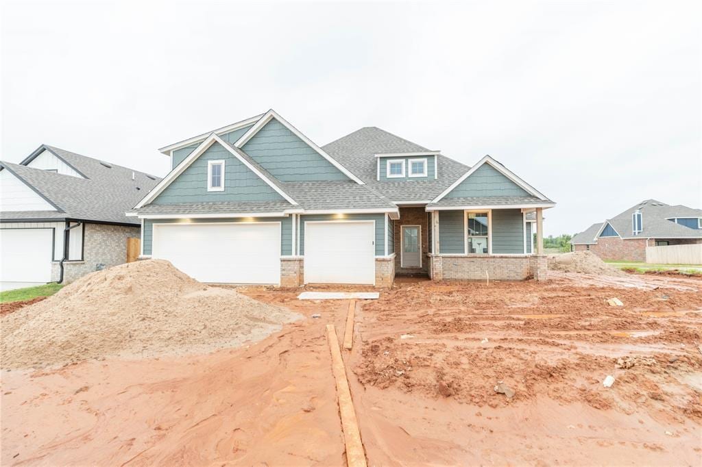 10372 SW 55th Ter, Mustang, OK 73064 - craftsman-style home with covered porch, roof with shingles, and driveway
