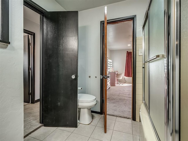 bathroom with toilet, tile patterned floors, and shower / bath combination with glass door