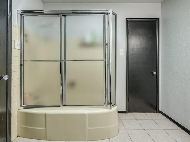 bathroom featuring bath / shower combo with glass door and tile patterned flooring