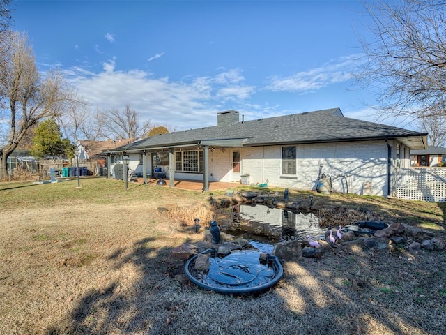 rear view of house featuring a yard and a patio