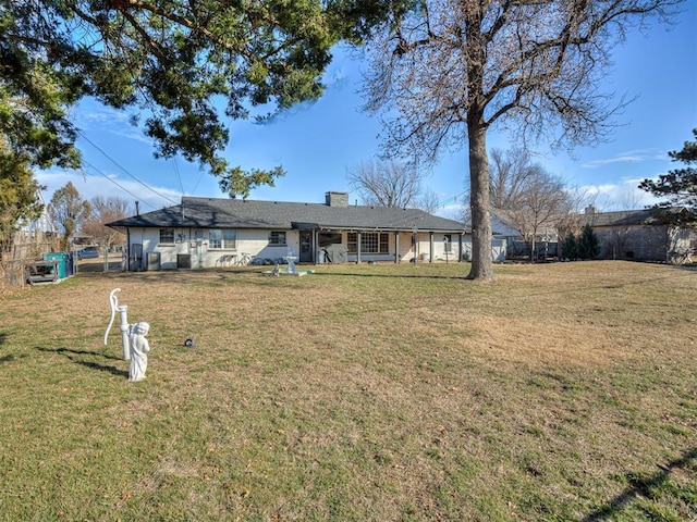 rear view of property with a yard