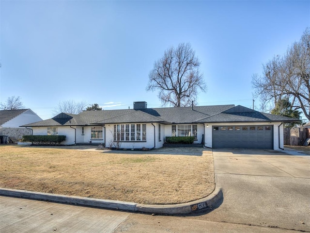 ranch-style home with a garage and a front lawn