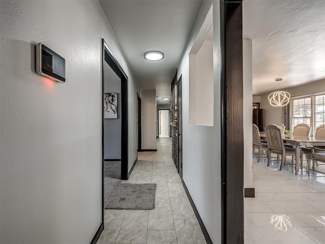 corridor with an inviting chandelier