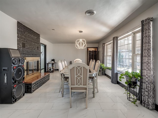 dining area featuring a multi sided fireplace and a chandelier