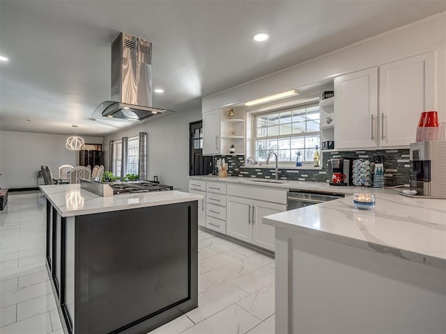 kitchen featuring white cabinetry, stainless steel appliances, sink, island range hood, and light stone counters