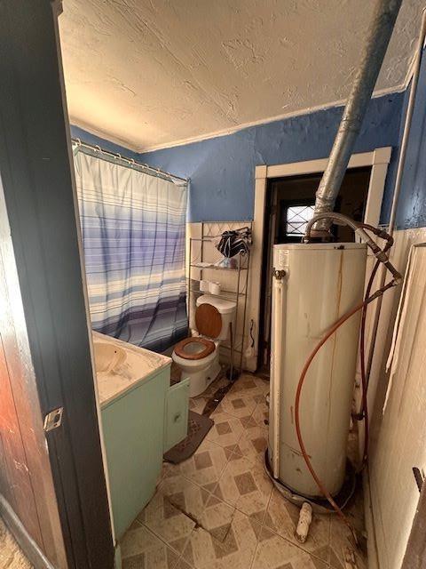 bathroom with toilet, gas water heater, and vanity