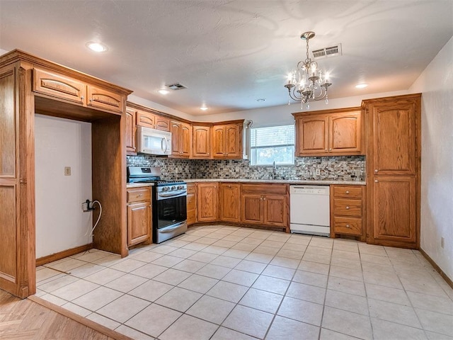 kitchen with decorative backsplash, white appliances, decorative light fixtures, and a notable chandelier