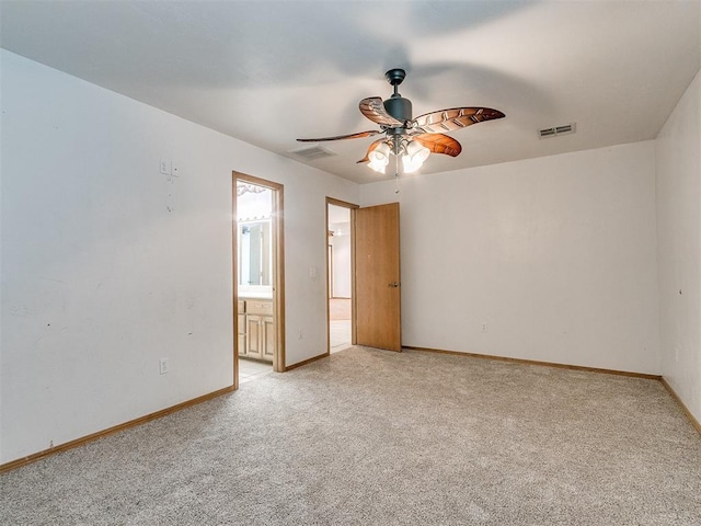 unfurnished bedroom with ceiling fan, light carpet, and ensuite bath