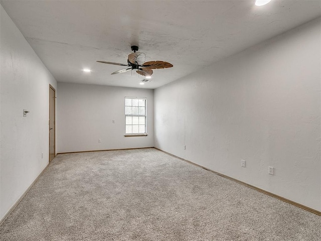 spare room featuring ceiling fan and light carpet