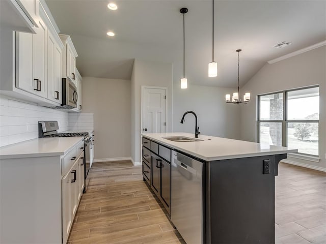 kitchen with sink, stainless steel appliances, backsplash, a kitchen island with sink, and white cabinets