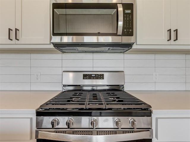 kitchen featuring tasteful backsplash, white cabinetry, and appliances with stainless steel finishes