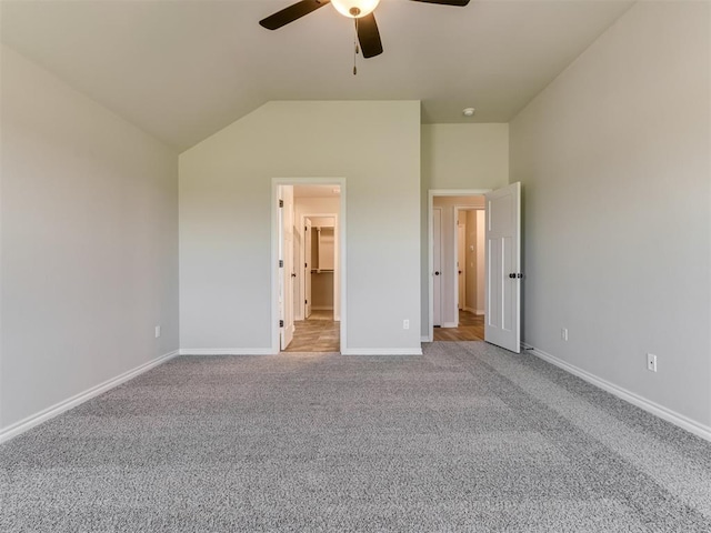 unfurnished bedroom with ceiling fan, light colored carpet, and vaulted ceiling