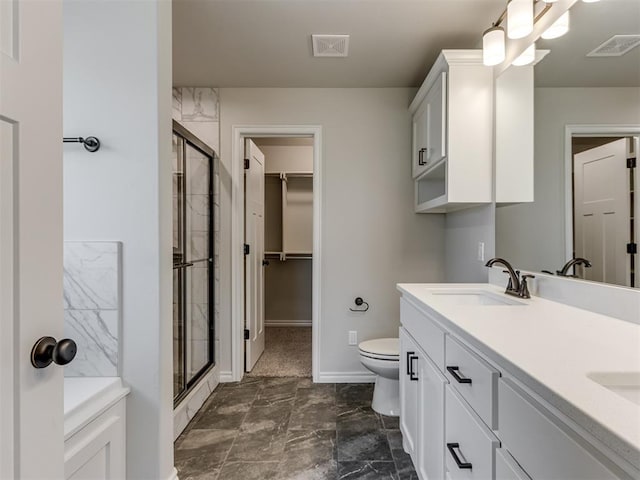 bathroom with vanity, toilet, and a shower with door