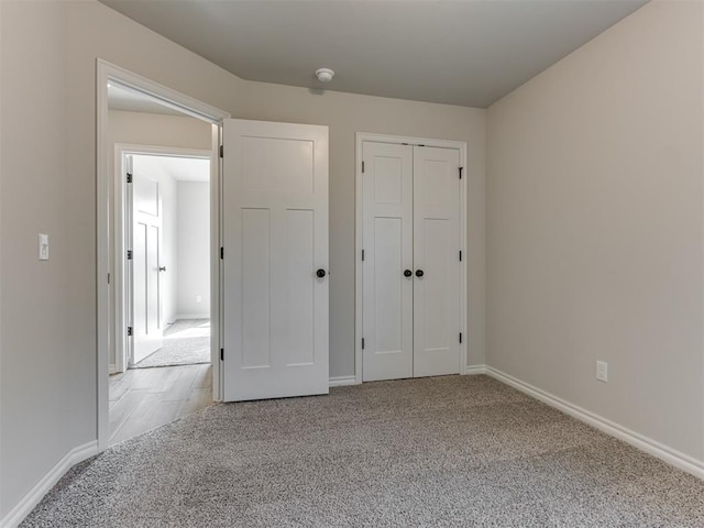 unfurnished bedroom featuring light colored carpet and a closet