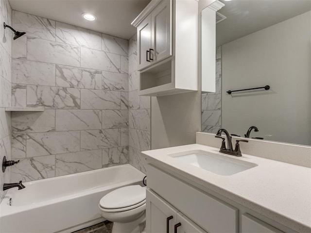 full bathroom with toilet, vanity, and tiled shower / bath